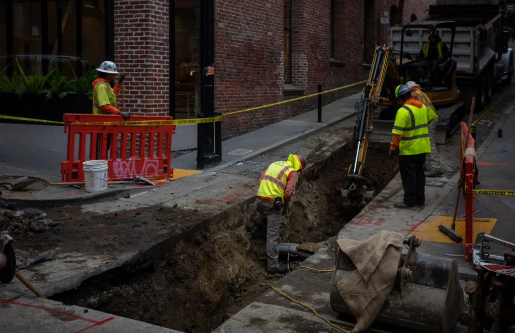 Workers digging a trench for a buried pipe